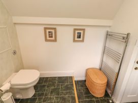 A bathroom with a toilet and towel rail at Coble Cottage in Craster
