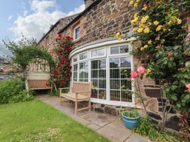 A garden with flowers and a bench at Coble Cottage in Craster