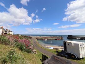 A coastal view with houses and boats at Coble Cottage in Craster
