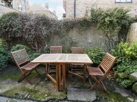 A garden with a wooden table and chairs at Percy Cottages No4 in Alnmouth
