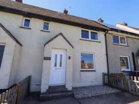 A cottage with a front door and windows at Dunford Cottage in Bamburgh