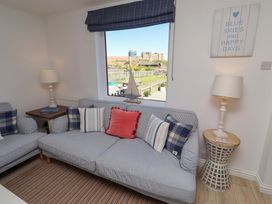 A living room with a sofa and wall art at Dunford Cottage in Bamburgh
