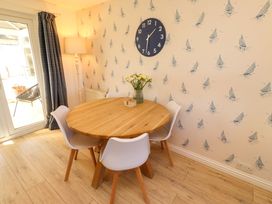A dining room with a round table and chairs at Dunford Cottage Bamburgh