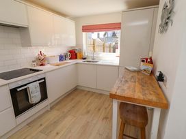 A kitchen with cabinets and a wooden countertop at Dunford Cottage in Bamburgh