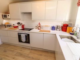 A kitchen with cabinets and appliances at Dunford Cottage in Bamburgh