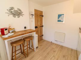 A kitchen with a wooden table and chairs at Dunford Cottage in Bamburgh