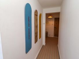 A hallway with skis on the wall and a door at Dunford Cottage in Bamburgh