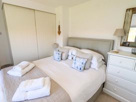 A bedroom with a bed and dresser at Dunford Cottage in Bamburgh