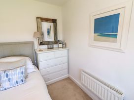 A bedroom with a bed and a dresser at Dunford Cottage in Bamburgh