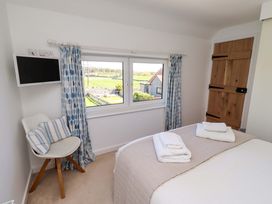 A bedroom with a bed and television at Dunford Cottage in Bamburgh