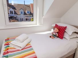 A bedroom with a bed and a stuffed toy at Dunford Cottage in Bamburgh