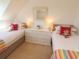 A bedroom with two beds and a dresser at Dunford Cottage in Bamburgh