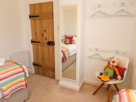 A bedroom with a bed and a chair at Dunford Cottage in Bamburgh