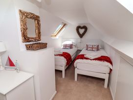A bedroom with twin beds and a decorative mirror at Dunford Cottage Bamburgh