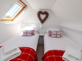 A bedroom with two beds and a heart decoration at Dunford Cottage in Bamburgh