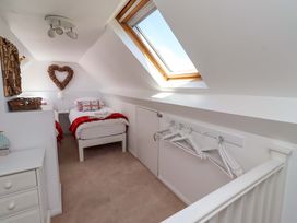 A bedroom with two beds and a window at Dunford Cottage in Bamburgh
