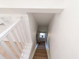 A staircase with a railing and window at Dunford Cottage Bamburgh