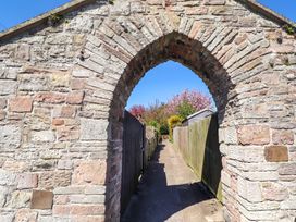 A stone archway leading to a pathway at Dunford Cottage Bamburgh