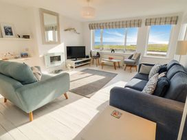 A living room with a television and sofas at Dell Point in Beadnell