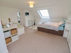 A bedroom with bed and mirror at Dell Point Beadnell
