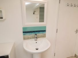 A sink with a mirror and splashback in the bathroom at Dell Point Beadnell