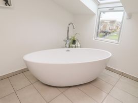 A bathroom with a bathtub and window at Dell Point Beadnell