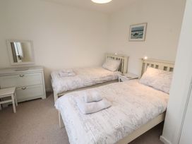 A bedroom with two beds and a dresser at Dell Point in Beadnell