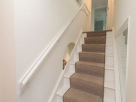 A staircase with carpet and handrail at Dell Point in Beadnell