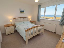 A bedroom with a bed and side tables at Dell Point in Beadnell