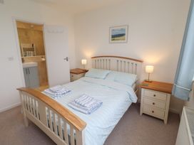 A bedroom with a bed and attached bathroom at Dell Point in Beadnell