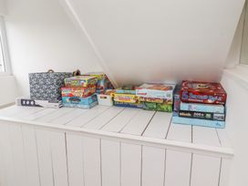 A shelf with board games and a storage basket at Dell Point Beadnell