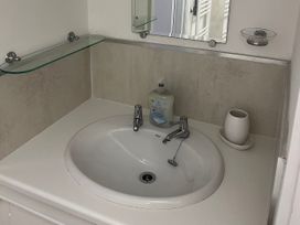 A bathroom sink with mirror and soap dispenser at Old Bakery No2 in Seahouses