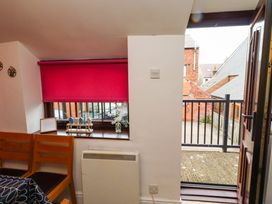 An interior view with a pink blind and sliding door at Old Bakery No2 Seahouses