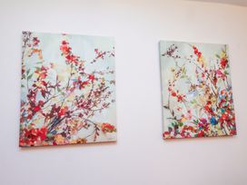 Two abstract flower paintings on a wall at Old Bakery No2 Seahouses