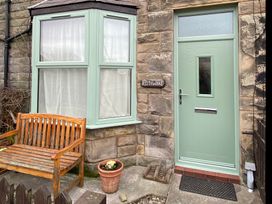 A green door and window beside a bench at Kittiwake Cottage in Seahouses