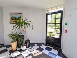 A hallway with plants and a door at Treetops, Alnwick