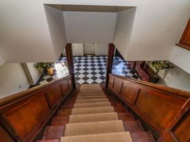 A staircase leading to a hallway with a checkered floor at Treetops, Alnwick