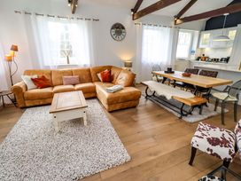 A living room with a sofa and dining table at Treetops, Alnwick