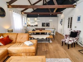 A living room with a sofa, dining area and kitchen at Treetops, Alnwick