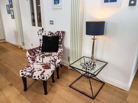 A living room with a chair and side table at Treetops, Alnwick