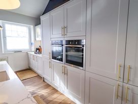A kitchen with cabinets, oven, and window at Treetops, Alnwick