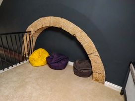 A landing with a stone arch and three bean bags at Treetops, Alnwick