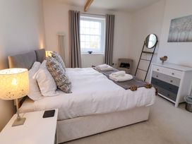 A bedroom with a bed and a dressing table at Treetops, Alnwick