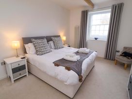 A bedroom with a bed and a bedside table at Treetops, Alnwick