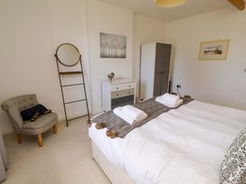 A bedroom with a bed and dresser at Treetops, Alnwick