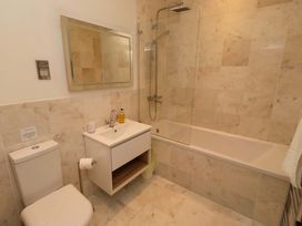 A bathroom with a sink, toilet, bathtub, shower, and mirror at Treetops, Alnwick