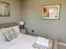 A bedroom with a bed and lamp at Treetops, Alnwick