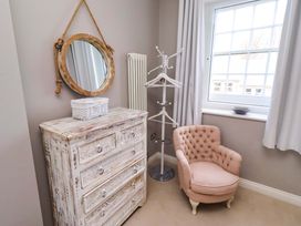 A bedroom with a mirror and dresser at Treetops, Alnwick