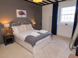 A bedroom with a bed and bedside tables at Treetops, Alnwick