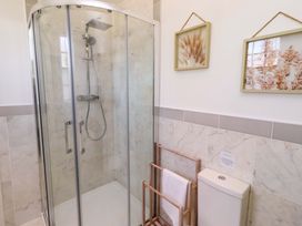 A bathroom with a shower and towel rack at Treetops, Alnwick